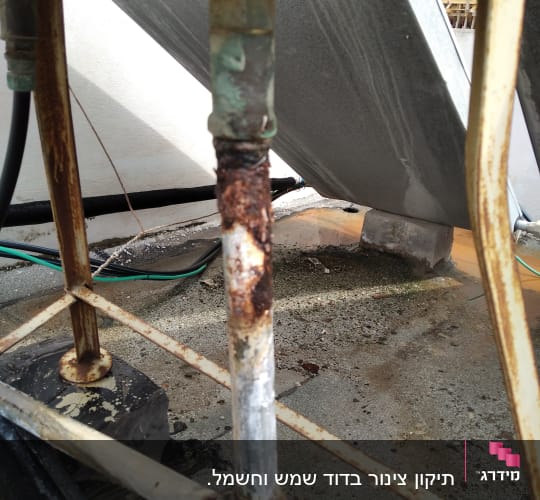 צינור חלוד עם סימני קורוזיה על הרצפה